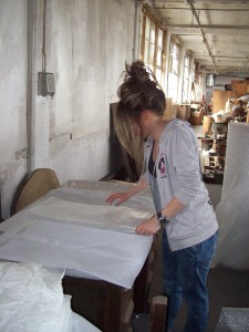 Intern Valia Goula takes a break from labelling and listing objects by making bubble wrap and acid-free tissue cushions that will protect the objects during transport.  